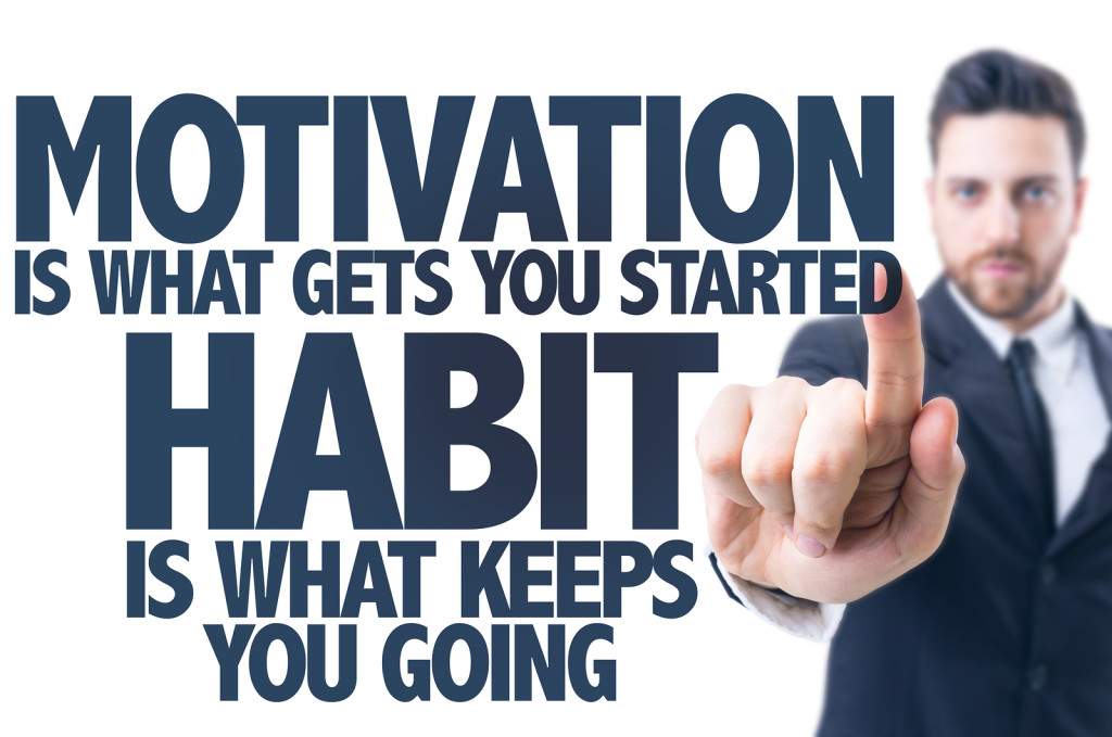 Business man pointing the text: Motivation is What Gets you Started Habit Is What Keeps You Going