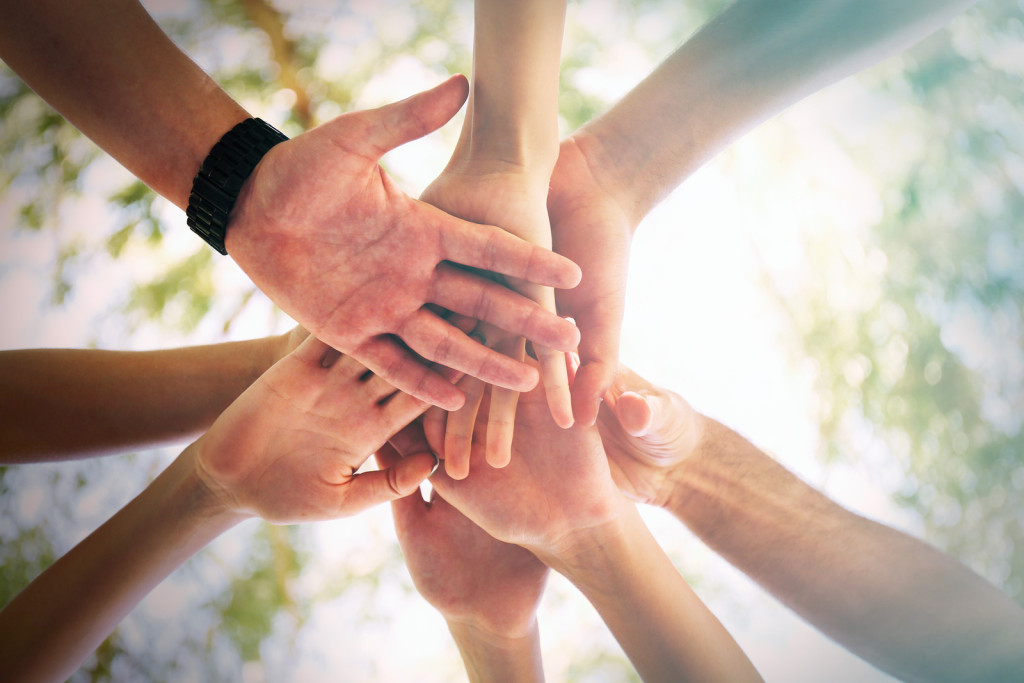 Hands of young people close up on sunny nature background